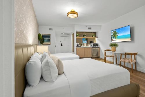 a bedroom with a white bed and a kitchen at Bentley Hotel South Beach in Miami Beach