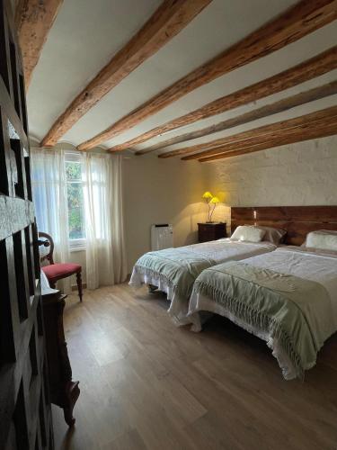a bedroom with two beds and a wooden ceiling at Casa La Sendera Alojamiento Rural en La Rioja in Santa Engracia