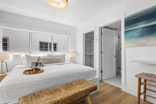 a white bedroom with a bed and a table at Bentley Hotel South Beach in Miami Beach