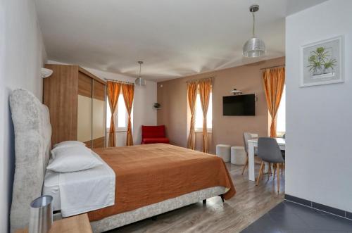 a hotel room with a bed and a table and chairs at Rooms & Apartments 72 in Zadar