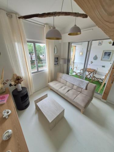 a living room with a couch and a table at Appartement avec piscine proche plages in Cap d'Agde