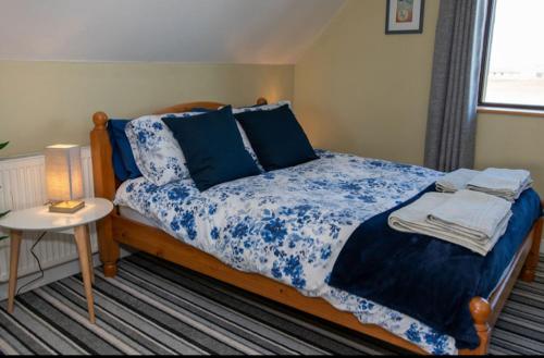 a bedroom with a bed with a blue and white comforter at Inskeyft - Kirkwall in Kirkwall