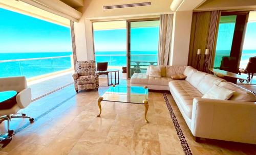 a living room with a couch and a table and chairs at Ocean Wrap Around Oceanfront Balcony at Tessoro in Las Conchas