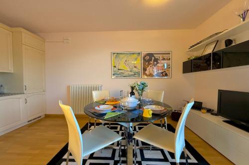 a dining room with a table with chairs and a television at Mastena Elegante in San Siro