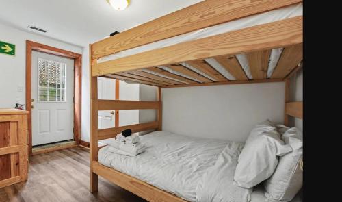 a bedroom with a wooden bunk bed with a ladder at Birch View- Balcony-Backyard-Parking-Sauna-Sleeps 20 in Blue Mountains