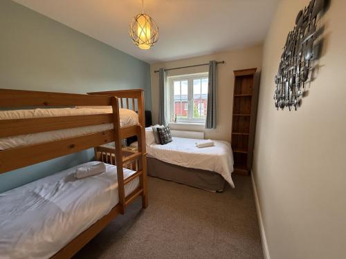 a bedroom with two bunk beds and a window at Anchors Away at The Bay Filey, sleeps 7, 2 dogs welcome for free too in Filey
