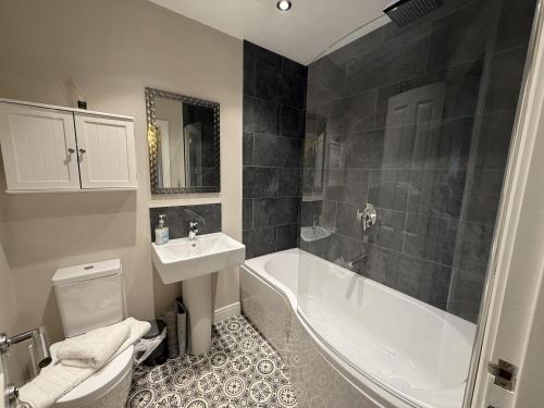 a bathroom with a toilet and a tub and a sink at Anchors Away at The Bay Filey, sleeps 7, 2 dogs welcome for free too in Filey