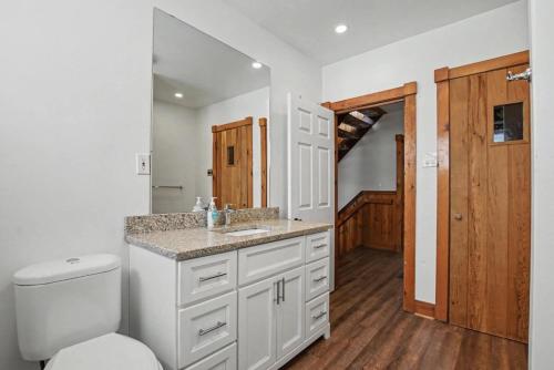 a white bathroom with a toilet and a sink at Birch View- Balcony-Backyard-Parking-Sauna-Sleeps 20 in Blue Mountains