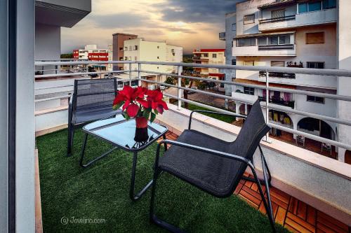 a table and chairs on a balcony with a vase of flowers at Almedina Silves in Silves