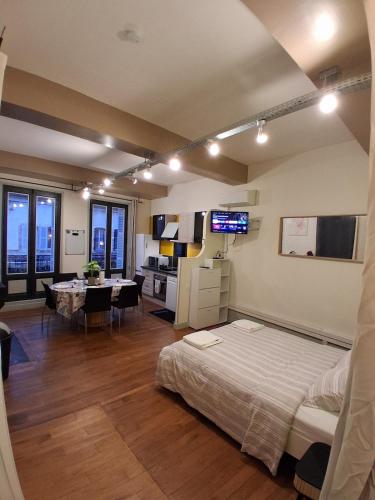 a bedroom with a bed and a kitchen and a dining room at Le Thiers Studio in Auxonne