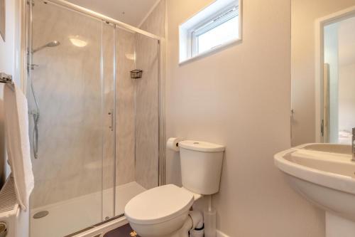 a bathroom with a shower and a toilet and a sink at 3 Bed in Tallington oc-s30309 in Yaxley