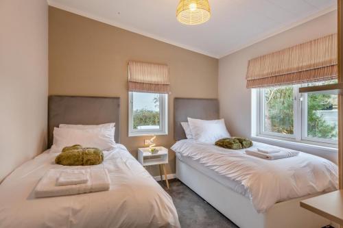 two beds in a room with two windows at 3 Bed in Tallington oc-s30309 in Yaxley