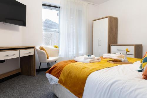 a bedroom with two beds and a desk and a television at Bristol Boutique Stay in Bristol
