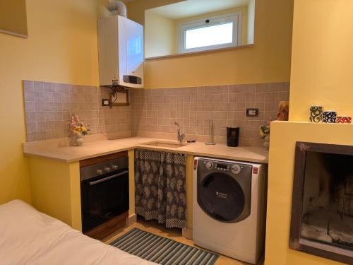 a kitchen with a sink and a washing machine at Il "Nido di Achille" in Centro - 2 piani di privacy e massimo comfort! in Terni