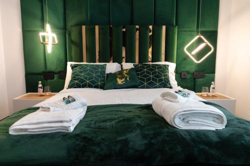 a green bedroom with towels on a bed at Bristol Boutique Stay in Bristol