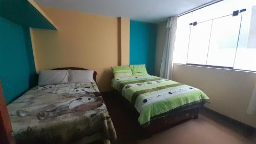 a bedroom with two beds and a window at Kenatural in Cajamarca