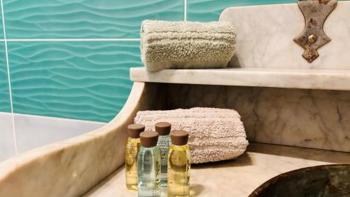 three bottles on a table next to a bath tub at BellaVista in Saluggia
