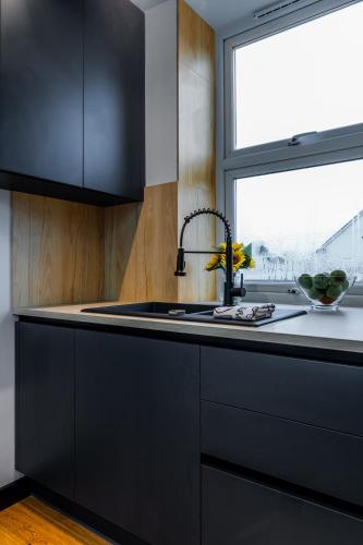 a black kitchen with a sink and a window at Bristol Boutique Stay in Bristol