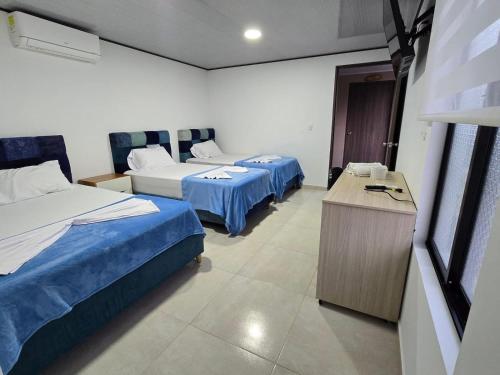 a hotel room with two beds and a table at Finca Ecoturística Canaguaros in Tauramena