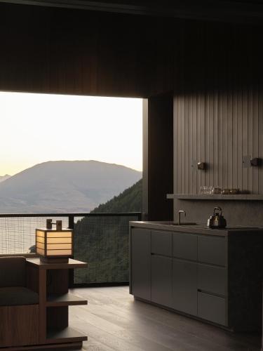 a kitchen with a large window with a view of the mountains at Moke Valley Queenstown in Queenstown