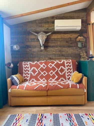 a couch in a living room with a fan at Chalet Majoie in Les Mages