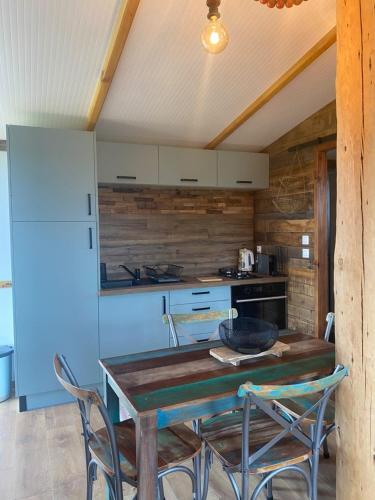 a kitchen with a table and chairs and a refrigerator at Chalet Majoie in Les Mages