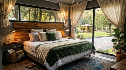 a bedroom with a large bed and a large window at Orgánico Hotel Boutique in Mexico City