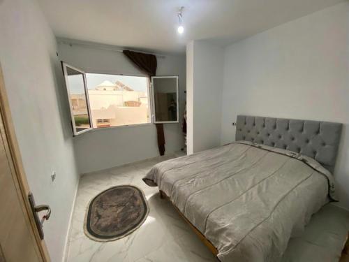 a bedroom with a large bed and a window at Villa Prestige sfax in Sfax