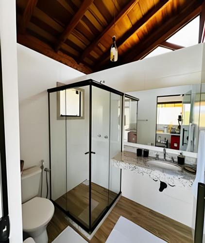 a bathroom with a glass shower and a toilet at Vinhedo Villarejo - Chalés do Vinhedo in Paty do Alferes