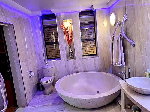 a bathroom with a large tub and a sink at The View on Nyle Rustenburg in Rustenburg