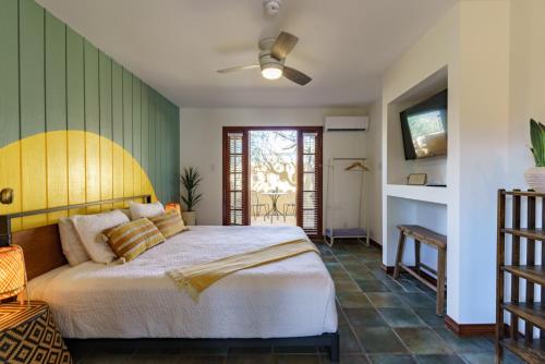 a bedroom with a large bed and a television at The Good House- Hot Spring Hideaway in Desert Hot Springs