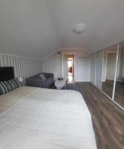 a bedroom with a large bed and a couch at Sommarlägenhet i Vadstena in Vadstena