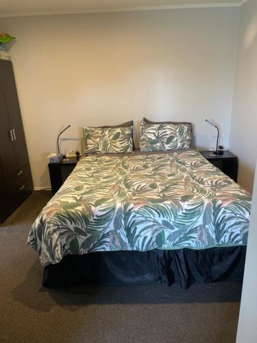 a bedroom with a large bed with two pillows at Quiet restful unit with seaviews in Auckland