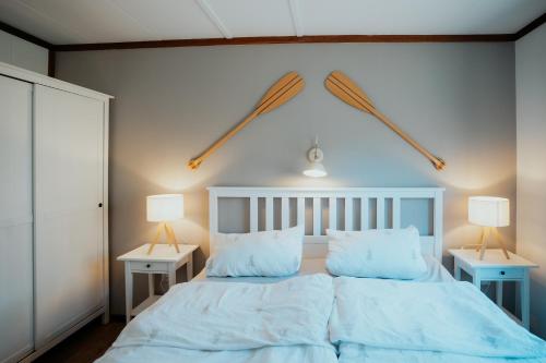a bedroom with a large bed with two lamps at Ferienwohnung Westerlicht - Apartment am Leuchtturm - De Torenhoeve in Nieuw-Haamstede