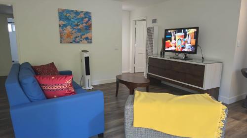 a living room with a blue couch and a tv at Resort-Style Family Getaway in Santa Monica in Los Angeles