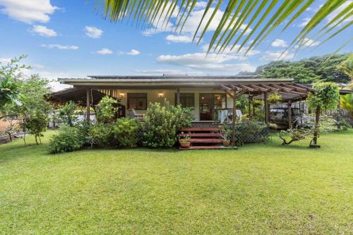 a house with a green lawn in front of it at Peaceful 2BR Garden Bungalow in Taravao