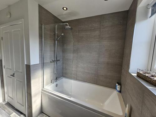 a bathroom with a tub and a glass shower at Sea Esta, The Bay, 2 bedrooms, patio garden, parking nearby, 2 dogs welcome in Filey