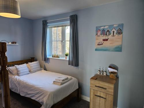 a bedroom with a bed and a window at Sea Esta, The Bay, 2 bedrooms, patio garden, parking nearby, 2 dogs welcome in Filey