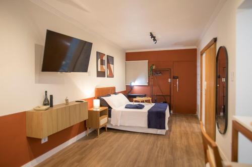 a bedroom with a bed and a tv on the wall at ApêBrisa73 in São Vicente