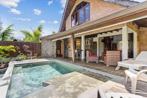 a house with a swimming pool and a patio at Charming Tropical Retreat with Private Pool in Taravao