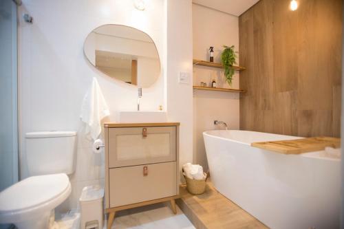 a bathroom with a tub and a toilet and a sink at ApêBrisa73 in São Vicente