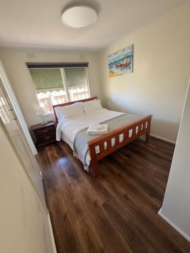 a bedroom with a large bed and a window at Ideal Melbourne Seaside Home in Mentone