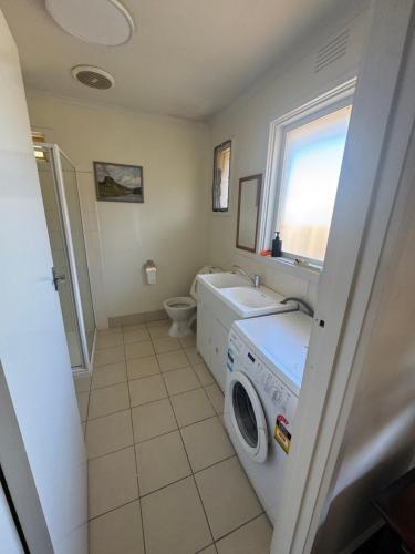 a bathroom with a washing machine and a sink at Ideal Melbourne Seaside Home in Mentone