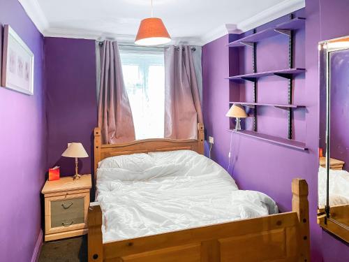 a bedroom with a bed and a purple wall at Turner Villa in Ramsgate