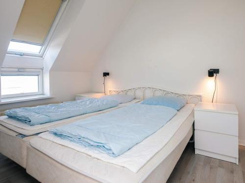two twin beds in a room with two lamps at 6 person holiday home on a holiday park in Hejls in Hejls
