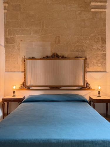a bedroom with a blue bed with two tables at Dimora 400 - nel cuore del Centro Storico di Lecce in Lecce
