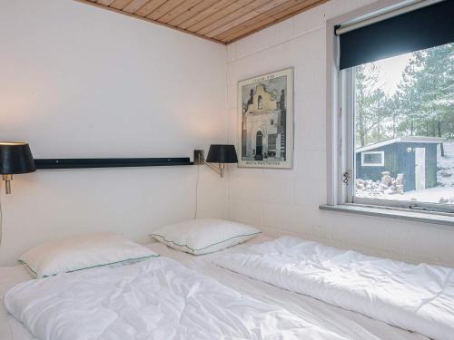 a bed sitting in a room with a window at 4 person holiday home in Blåvand in Blåvand