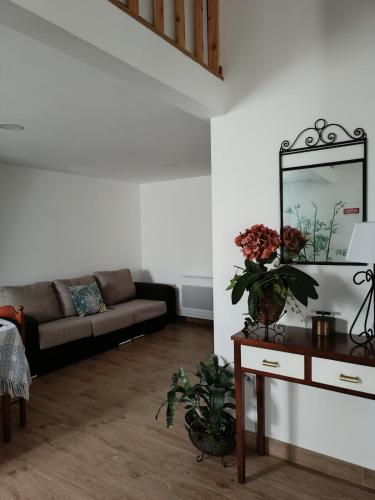 a living room with a couch and a table with a mirror at Casa da Canhota in São Mamede