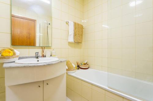 a bathroom with a sink and a tub at Casa Nobrega in Caniço