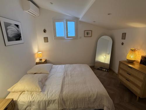 a bedroom with a bed and a dresser and a window at Cabanon des calanques aux Goudes in Marseille